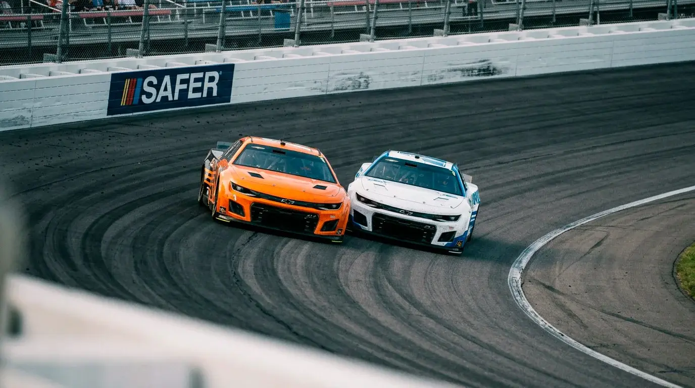 Dos coches NASCAR rueda a rueda en curva, representación del mercado head-to-head de apuestas